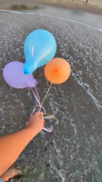 Drie Kleurrijke Opblaasbare Ballen Achtergrond Van Zee Sterke Wind Persoon — Stockvideo