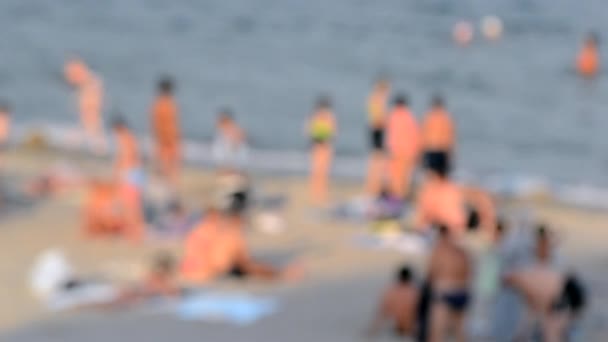 사람들이 해변의 해변에서 휴식을 취하고 뜨거운 바다에서 여름에 해변에 사람들 — 비디오