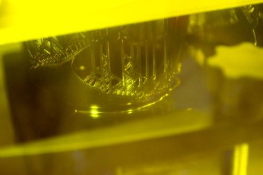 Fotopolymer sla 3D yazıcı çalışıyor. Bina nesnesinin bulunduğu platform sıvı fotopolimer reçinelere indirgenmiş ve ultraviyole lazer altında sertleştirilmiş. Yenilikçi katkı teknolojisi. 3B yazıcı yazdırma