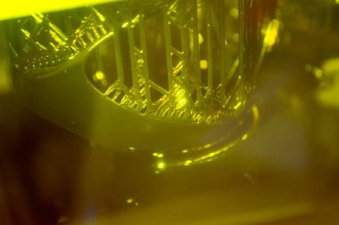 Fotopolymer sla 3D yazıcı çalışıyor. Bina nesnesinin bulunduğu platform sıvı fotopolimer reçinelere indirgenmiş ve ultraviyole lazer altında sertleştirilmiş. Yenilikçi katkı teknolojisi. 3B yazıcı yazdırma