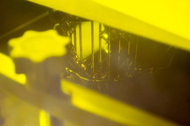 3D yazıcıda yakın plan baskı modelleri. 3D yazıcının içindeki baskı platformunda sıvı fotopolimer reçinelerden fotopolimer sla 3D yazıcıya basılan nesneler. Modern yenilikçi katkı teknolojisi.