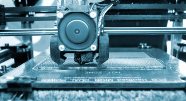 3D yazıcı bir model basıyor. Erimiş plastikten bir model yazdırma işlemi sırasında bir 3D yazıcının ekipmanı
