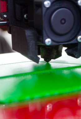 3D yazıcı bir model basıyor. Erimiş plastikten bir model yazdırma işlemi sırasında bir 3D yazıcının ekipmanı