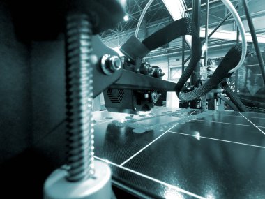 3D yazıcı bir model basıyor. Erimiş plastikten bir model yazdırma işlemi sırasında bir 3D yazıcının ekipmanı