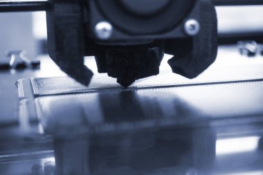 3D yazıcı kapat. Çalışan bir 3D yazıcı erimiş plastikten bir nesne yazdırıyor. 3D yazıcı, bir yazıcıdan sıvı plastik akışı ile model oluşturuyor. 3D yazdırma teknolojisi