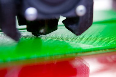 3D yazıcı kapat. Çalışan bir 3D yazıcı erimiş plastikten bir nesne yazdırıyor. 3D yazıcı, bir yazıcıdan sıvı plastik akışı ile model oluşturuyor. 3D yazdırma teknolojisi