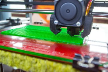 3D yazıcı kapat. Çalışan bir 3D yazıcı erimiş plastikten bir nesne yazdırıyor. 3D yazıcı, bir yazıcıdan sıvı plastik akışı ile model oluşturuyor. 3D yazdırma teknolojisi