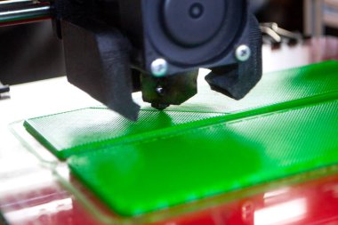 3D yazıcı bir model basıyor. Erimiş plastikten bir model yazdırma işlemi sırasında bir 3D yazıcının ekipmanı