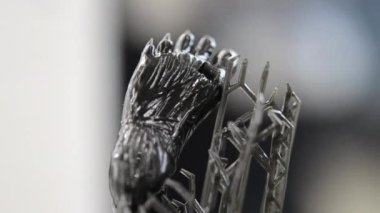 Siyah kauçuktan üç boyutlu yazıcıya basılmış bacak modeli, yakın plan. Ultraviyole ışığın etkisiyle sertleştirilmiş kauçuktan üç boyutlu yazıcıda yaratılan bir nesnenin parçası. SLA 3D yazdırma teknolojisi.
