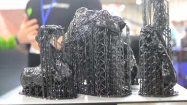 3D yazıcıya yakın çekimde destekli siyah model. Ultraviyole ışığın etkisiyle sertleştirilmiş kauçuktan 3 boyutlu yazıcıda yaratılan nesnenin bir parçası. SLA 3D baskı teknolojisi. Stereolitografi