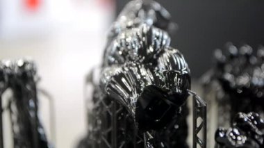 3D yazıcıya yakın çekimde destekli siyah model. Ultraviyole ışığın etkisiyle sertleştirilmiş kauçuktan 3 boyutlu yazıcıda yaratılan nesnenin bir parçası. SLA 3D baskı teknolojisi. Stereolitografi