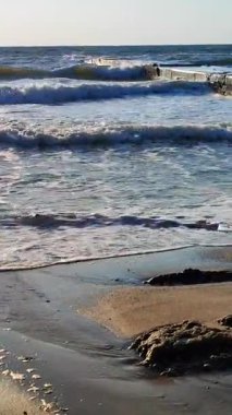 Fırtına sırasında dalgalı su. Güneşli bir yaz gününde, deniz kıyısında beton dalgaları kesen dalgalar. Deniz manzarası. Deniz manzaralı. Sahildeki sahil şeridi. Doğa, doğal altyapı. Dikey