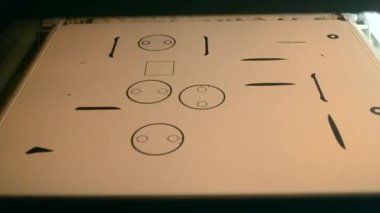 Toz endüstriyel 3D yazıcı beyaz plastik baruttan çıkan üç boyutlu hacimli modeller basıyor. Beyaz yüzeydeki nesnelerin siyah hatları. Siyah kafa 3B yazıcının yüzeyinde hareket ediyor