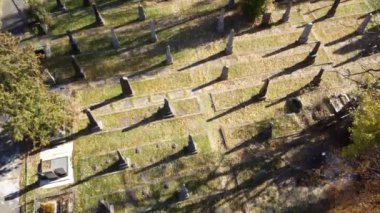 Mezar taşları, mezar taşları, mezar taşları ve oklarla eski mezarlığın üzerinden insansız hava aracı uçuşu. Güneşli bir sonbahar gününde insansız hava aracı bakış açısı. Ölülerin gömülmesi. Toprağa gömülmek. Tarihi Anıt