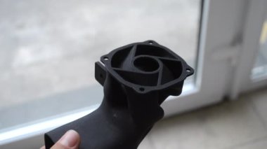 Podyum tozundan çıkan 3D yazıcıya basılmış plastik model tutan adam. Çoklu Jet Füzyon MJF. Üç boyutlu yazıcı, üç boyutlu modeller basmış. Yeni modern katkı maddesi endüstriyel 3D baskı teknolojisi