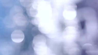 Güneşli yaz gününde deniz manzarası. Deniz Burnu. Mavi deniz suyu yüzeyli deniz manzarası, küçük dalgalanmalar, beyaz bokeh noktaları ve güneşi yansıtan parlak noktalar. Bulanık soyut doğal arkaplan dikey