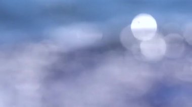 Güneşli bir yaz gününde deniz manzarası. Deniz Burnu. Mavi deniz suyu yüzeyli deniz manzarası, küçük dalgalanmalar ve güneşi yansıtan parlak lekeler. Bulanık soyut doğal arkaplan