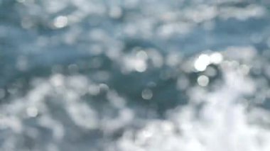 Güneşli bir yaz gününde deniz manzarası. Deniz Burnu. Mavi deniz suyu yüzeyli deniz manzarası, küçük dalgalanmalar ve güneşi yansıtan parlak lekeler. Bulanık soyut doğal arkaplan