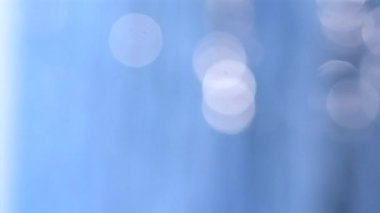 Güneşli yaz gününde deniz manzarası. Deniz Burnu. Mavi deniz suyu yüzeyli deniz manzarası, küçük dalgalanmalar, beyaz bokeh noktaları ve güneşi yansıtan parlak noktalar. Bulanık soyut doğal arkaplan dikey