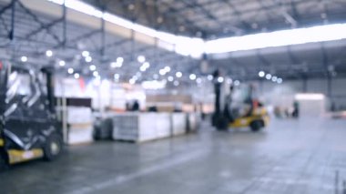 Büyük bina içinde inşaat çalışmaları. Bina enstalasyon sergi merkezi. Şantiyede yükleyici makinesi. Kurulum işinde birçok kişi çalışır. Bulanık Arka Plan