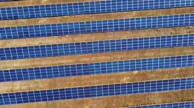 Hava aracı güneş enerjisi istasyonu panelleri üzerinde uçuyor. Güneş çiftliğinin havadan görünüşü. Yeşil enerji, elektriksel yenilik. Yenilenebilir Enerji. Güneş enerjisi üreten endüstriyel güneş enerjisi çiftliği.