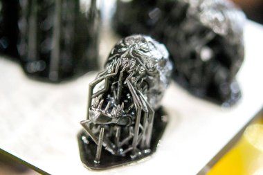 Siyah kauçuktan üç boyutlu bir yazıcıya yakın plan baskılı kafa modeli. Ultraviyole ışığın etkisiyle sertleştirilmiş kauçuktan üç boyutlu yazıcıda yaratılan bir nesnenin parçası. SLA 3D yazdırma teknolojisi.