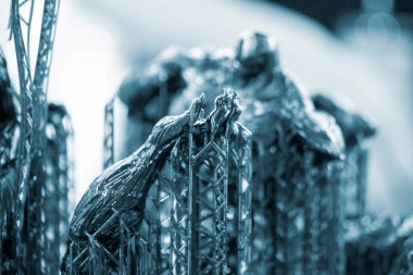 Siyah kauçuktan üç boyutlu bir yazıcıya yakın plan el baskısı. Ultraviyole ışığın etkisiyle sertleştirilmiş kauçuktan üç boyutlu yazıcıda yaratılan bir nesnenin parçası. SLA 3D yazdırma teknolojisi.