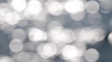 Deniz. Mavi denizin soyut görüntüsü, suda dalgalanmalar ve güneşli bir yaz gününde parlayan beyaz güneş. Doğa. Doğal arka plan. Arka plan bulanık. Yaz tatili turizmi kavramını