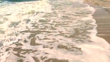 Deniz dalgaları yaz güneşli bir günde kumlu bir sahilde dalgalanır. Doğa. Doğal arkaplan