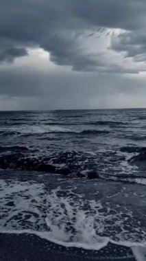 Karanlık fırtına bulutları, yağmur ve deniz yüzeyi gün batımında. Doğa. Doğal arka plan. Fırtınalı hava. Denizde fırtına. Dikey