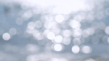 Güneşli bir yaz gününde soyut deniz manzarası. Bulanık doğa geçmişi. Birçok beyaz, yuvarlak, deniz dalgalarının mavi yüzeyinde parlayan güneşi yansıtan noktalar var. Doğa.