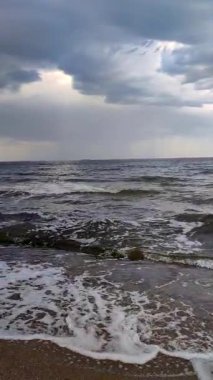 Denizde yağmur ve fırtına. Karanlık fırtına bulutları, yağmur ve deniz yüzeyi gün batımında. Doğa. Doğal arka plan. Fırtınalı hava. Denizde fırtına. Dikey