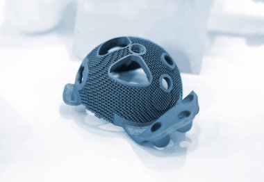 Biyolojik uyumlu titanyumdan üç boyutlu yazıcıya eklem implantı yerleştirilmiş. Bireysel 3 boyutlu asetabüler sistem. Endoprotez. Biyoentegre hastaya özgü protez. Sağlık sigortası