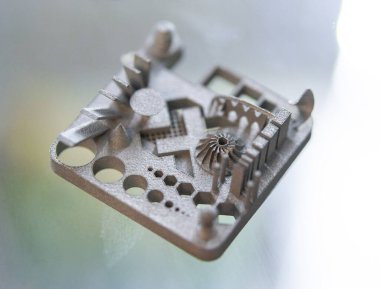Metal Jet teknolojisi kullanılarak metal tozundan 3D yazıcıya basılmış bir nesne. Ayrıntılı detaylar. Metal Jet. 3D baskılı metal parçaları. Modern 3D baskı, katkı maddesi üretim teknolojileri