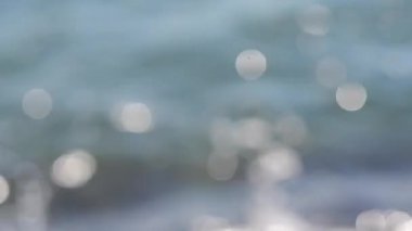Güneşli bir yaz gününde deniz manzarası. Deniz Burnu. Mavi deniz suyu yüzeyli deniz manzarası, küçük dalgalanmalar ve güneşi yansıtan parlak lekeler. Bulanık soyut doğal arkaplan