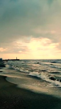 Denizde yağmur ve fırtına. Karanlık fırtına bulutları, yağmur ve deniz yüzeyi gün batımında. Doğa. Doğal arka plan. Fırtınalı hava. Denizde fırtına. Dikey