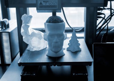 Sanat modelleri 3D yazıcının masaüstündeki 3D yazıcıya basıldı. Beyni, tavşanı ve 3 boyutlu yazıcıya farklı renklerde erimiş plastikten basılmış Noel ağacının prototip insan kafası modelleri.