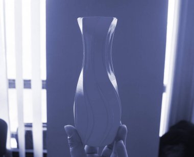 Mavi vazo modelini elinde tutan kişi, 3D yazıcıya basılmış, mavi duvara karşı. Erimiş plastik mavi renkten 3 boyutlu yazıcıya basılmış üç boyutlu model. Konsept 3 boyutlu baskı. FDM 3D Yazdırma teknolojisi