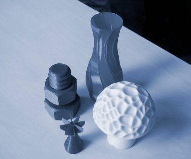 Several art objects printed on a 3D printer. Model blue vase, white mushroom, tip, gray washer and bolt created 3D printer from molten plastic. Additive progressive technology clipart