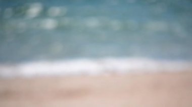 Deniz bulanık arkaplan. Güneşli bir günde denizin su yüzeyinin soyut görüntüsü. Güneşin deniz yüzeyinde parladığı bulanık beyaz bokeh noktaları. Doğal soyut arka plan. Deniz güneşli zemin Dikey