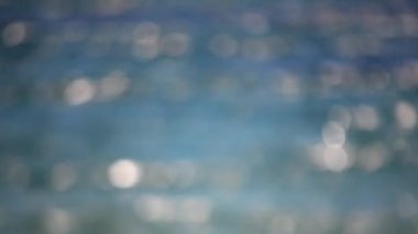 Mavi denizin soyut görüntüsü dalgalar ve güneşli bir yaz gününde dalgalanmalardan oluşan beyaz benekler. Hareket eden okyanus nehir gölü suyu. Doğal arka plan. Doğa arkaplanı. Bulanık arkaplan.