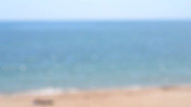 Deniz. Mavi deniz suyu, dalgalar, beyaz köpük, kumlu sahil, mavi gökyüzü. Hiç kimse. Yaz güneşli bir gün. Deniz kıyısı deniz manzarası. Arka plan bulanık. Doğal soyut arka plan. Doğa bokeh arkaplanı.