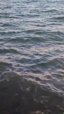 Deniz manzaralı. Gün boyunca deniz dalgaları ve gökyüzü olan mavi deniz manzarası. Deniz Burnu. Yüzeyde büyük dalgalanmalarla deniz yüzeyinin görüntüsü. Doğal soyut doku arka planı. Dikey