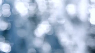 Deniz. Mavi denizin soyut görüntüsü, suda dalgalanmalar ve güneşli bir yaz gününde parlayan beyaz güneş. Doğa. Doğal arka plan. Arka plan bulanık. Yaz tatili turizmi düşey konseptini kabul et