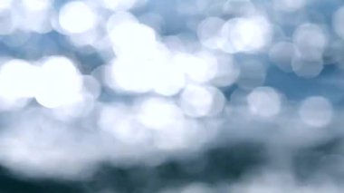 Deniz. Mavi denizin soyut görüntüsü, suda dalgalanmalar ve güneşli bir yaz gününde parlayan beyaz güneş. Doğa. Doğal arka plan. Arka plan bulanık. Yaz tatili turizmi kavramını