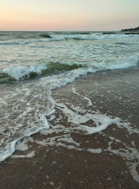 Fırtınalı deniz. Gün batımında ve şafakta denizde beyaz köpüklü büyük dalgalar. Sahil kıyısı kıyı şeridi. Doğal arka plan doğa fırtınası