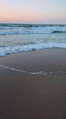 Deniz dalgaları kumsal kumsalı şafağı. Doğal arka plan. Dikey