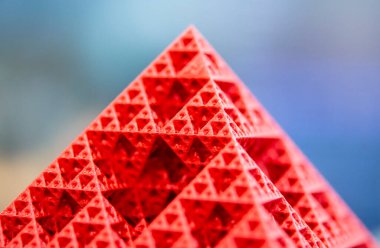 Kırmızı erimiş plastikten çıkan 3 boyutlu yazıcıya basılmış sanat eseri. Plastikten 3D yazıcıda oluşturulan piramit modeli. 3D baskı teknolojisi. Katkı sağlayan yenilikçi teknoloji. Yeni modern teknolojiler