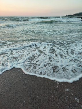 Fırtınalı deniz. Gün batımında ve şafakta denizde beyaz köpüklü büyük dalgalar. Sahil kıyısı kıyı şeridi. Doğal arka plan doğa fırtınası