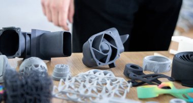 Erimiş plastik tozundan üç boyutlu yazıcıya çeşitli nesneler basılmış. Erimiş siyah gri poliyamid tozundan 3 boyutlu yazıcıya basılmış farklı modeller. Katkı 3D baskı Çok Jet Füzyon MJF teknolojisi